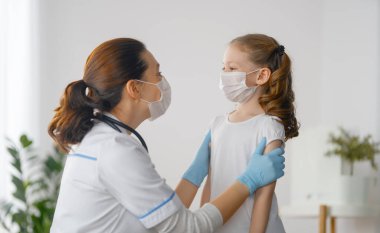 Doktor ve çocuk koronavirüs ve grip salgını sırasında maske takıyor. Virüs koruması. COVID-2019. Maske takıyor.