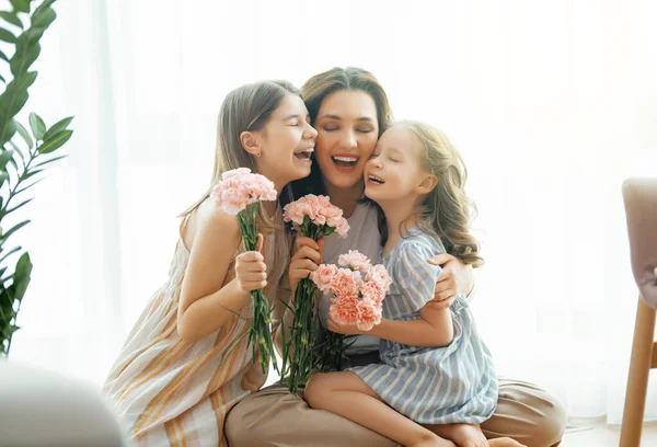 快乐的一天 孩子们的女儿们在向母亲道贺 送她鲜花 妈妈和女孩笑着拥抱 家庭假日和团聚 — 图库照片