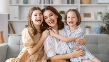 Mutlu bir gün! Anne ve kızları oynuyorlar, gülüyorlar ve sarılıyorlar. Aile tatili ve birliktelik. 