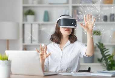 Metaverse technology concept. Woman with VR virtual reality goggles is working in the office. Futuristic lifestyle. clipart