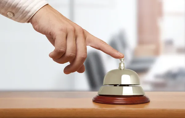 Mano de un hombre usando una campana de hotel — Foto de Stock