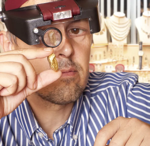 Um homem segurando uma jóia de pepita de ouro — Fotografia de Stock