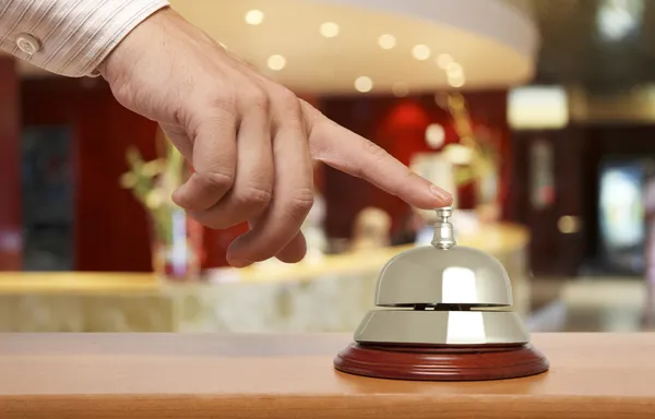 Mano de un hombre usando una campana de hotel — Foto de Stock