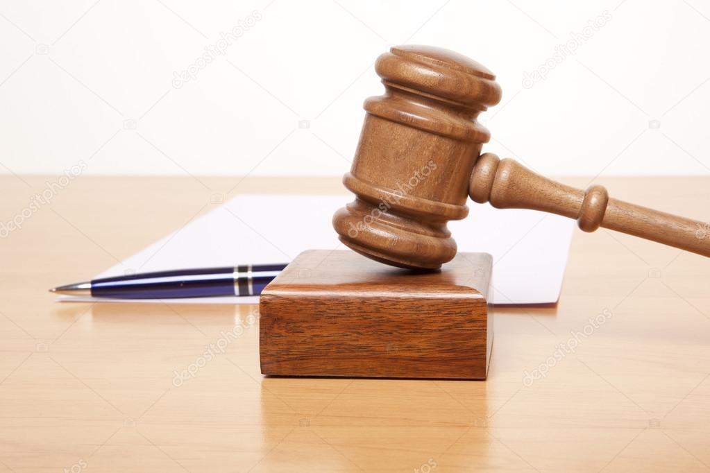 Gavel, a pen and a paper on the table