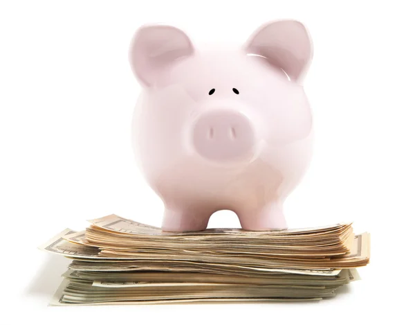 Roze piggy bank op een stapel van dollar — Stockfoto