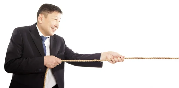 Asian businessman pulling a rope — Stock Photo, Image