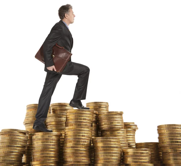 Businessman goes up coins — Stock Photo, Image