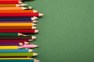 Yeşil arkaplanda renkli kalemler