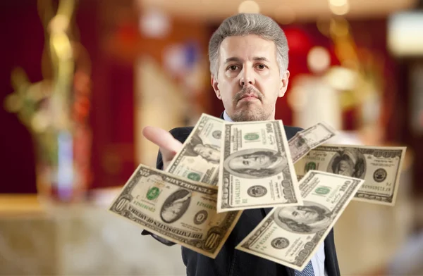 Бизнесмен бросает доллар — стоковое фото