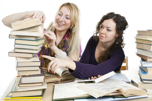 Isolato su bianco due ragazze con libri sul tavolo — Foto Stock