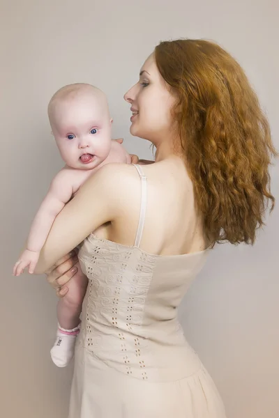 Mãe segura o bebê em mãos e fala com ele — Fotografia de Stock