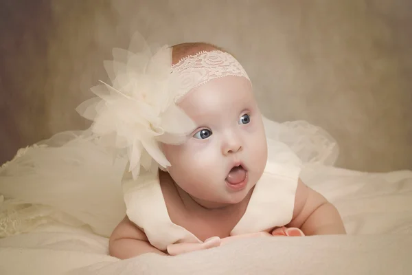 O bebê em um vestido está em um travesseiro — Fotografia de Stock