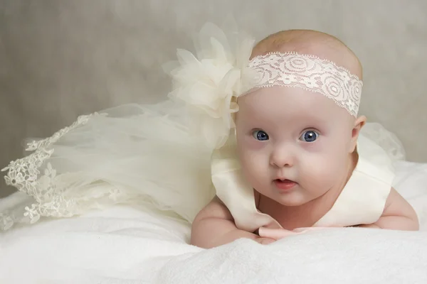 The baby in a dress lies on a pillow — Stock Photo, Image