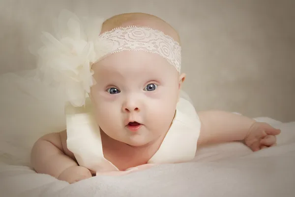 El bebé en un vestido yace sobre una almohada —  Fotos de Stock