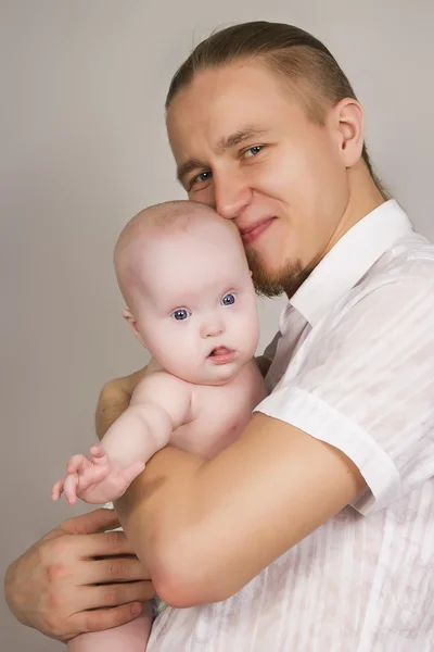 O pai abraça o recém-nascido e sorri Imagem De Stock