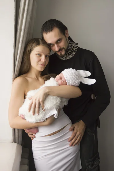 Jovem família com o bebê em casa — Fotografia de Stock