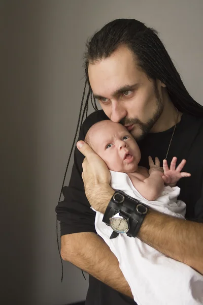 De jonge vader omarmt de baby Stockfoto