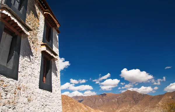 Monasterio tibetano contra el cielo azul y las montañas de fondo —  Fotos de Stock