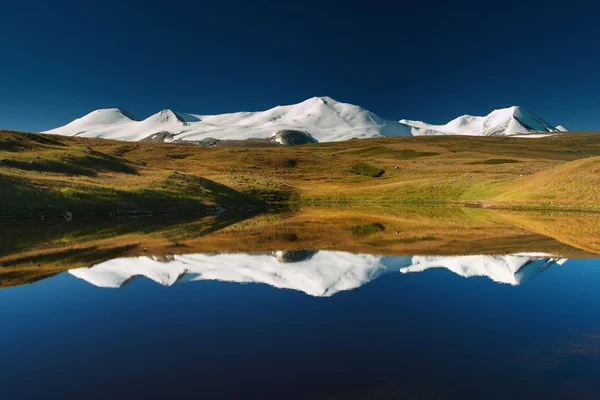 Snötäckta berg återspeglas i sjön, platå ukok — Stockfoto