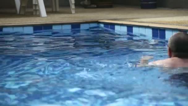 Muž v bazénu. — Stock video