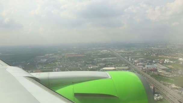 Aile de l'avion, ciel, nuages et bâtiments sous — Video