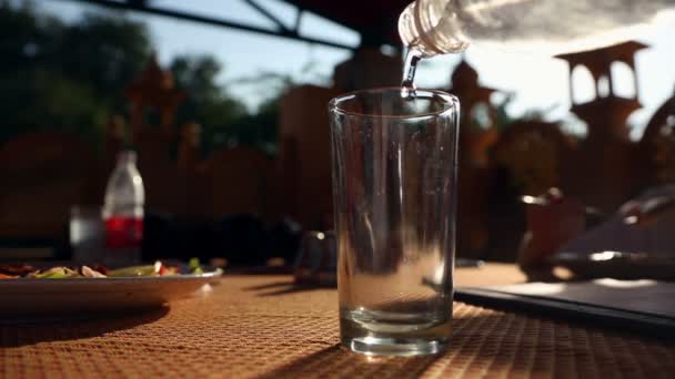 Pouring water into glass during lunch — Stock Video