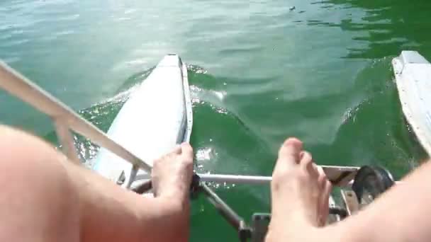 Mannelijke voeten trappen waterfiets — Stockvideo