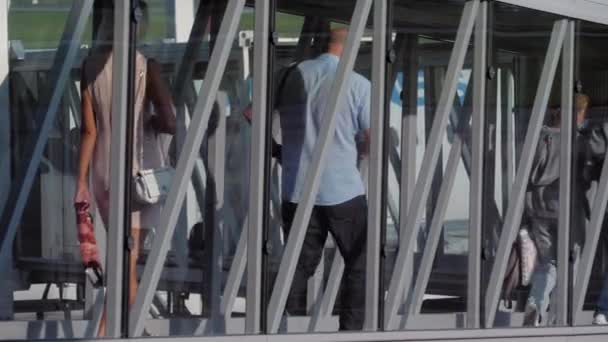Cestující nastupující na skleněném mostě — Stock video