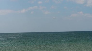 Uçak okyanusun üzerinde alçaktan uçuyor.