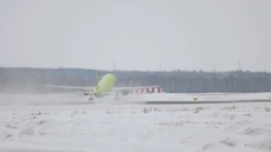 Uçak kar fırtınası ile havalanıyor.