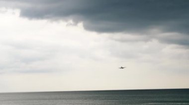 Uçak denizin üzerinde alçaktan uçuyor.