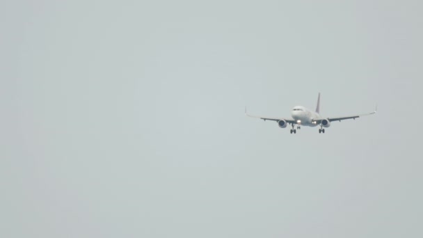 Avión vuela en el cielo lluvioso gris bajo — Vídeo de stock