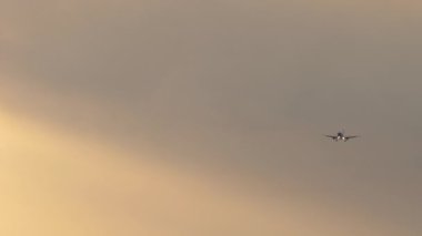 Airplane at sunset, long shot