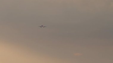 Airplane at sunset, long shot