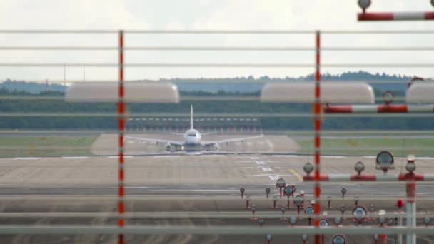 民間航空会社 空港信号灯を介してフロントビューを離陸 認識できない飛行機が飛んでいく — ストック動画