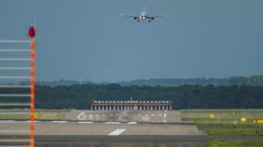 Front view, jet passenger airplane descending for landing to Dusseldorf airport DUS. Airplane approaching, view from the end of the runway. Tourism and travel concept