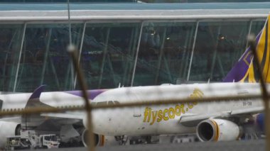 PHUKET, THAILAND - NOVEMBER 26, 2017: Commercial airplane Airbus A319 of Scoot taxiing at Phuket Airport HKT. Airplane at the airport, view through the fence. Tourism and travel concept, air flight