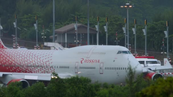 プーケット 2019年11月28日 Civil Boeing 747 Rossiyaは プーケット空港で離陸する前に滑走路に乗ります 熱帯雨の日に飛行場に飛行機 — ストック動画