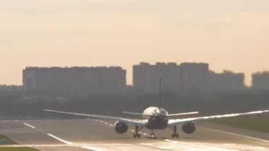Footage rear view of unrecognizable passenger plane picks up speed to take off. Airliner reflects sun glare. Traffic airfield airport
