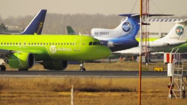 NOVOSIBIRSK, RUSSIAN FEDERATION - OCTOBER 20, 2021: Airplane Airbus A320 of S7 Airlines taxiing to the runway. Passenger airliner on the airfield, sun glare