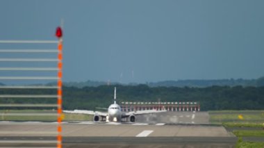 Passenger jet aircraft raised flaps and slows down after landing. Unrecognizable Airliner arrived at the airport on a summer day. Tourism and travel concept