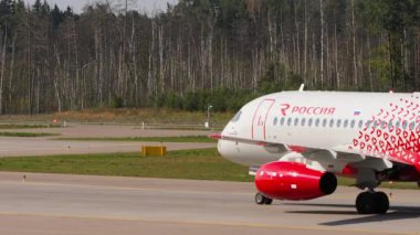MOSCOW, RUSSIAN FEDERATION - JULY 31, 2021: Mid shot of Sukhoi Superjet on the airfield. Sukhoi Superjet of Rossiya taxiing at Sheremetyevo Airport SVO. Tourism and travel concept.