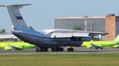 NOVOSIBIRSK, RUSSIAN FEDERATION - JUNY 12, 2022: IL 76MD cargo transport aircraft landing and braking at Tolmachevo airport, side view, medium shot