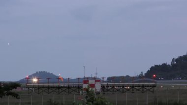 Aircraft landing and braking, view through airport fence. Passenger airliner arrival at the airport. Tourism and travel concept.