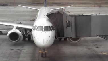 NOVOSIBIRSK, RUSSIA - APRIL 19, 2015: View from the terminal window, Air Astana plane and telescopic bridge at Tolmachevo airport OVB. Passenger plane at the gate