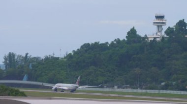 PHUKET, THAILAND - NOVEMBER 28, 2019: Airplane of Qatar Airways take off at Phuket airport. View from the top floor of the hotel near airport. Tourism and travel concept, air flight