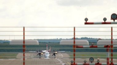 Turboprop passenger aircraft braking after landing, front view. Airliner arriving at the airport
