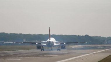 Passenger plane braking after landing, rear view. Unrecognizable airliner arrived at the airport