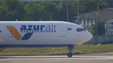 PHUKET, THAILAND - NOVEMBER 29, 2019: Azur Air commercial aircraft on the taxiway at Phuket airport, side view. Tourism and aviation concept