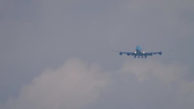 Long shot of widebody approaching before landing. Double-deck airliner with four engines flies